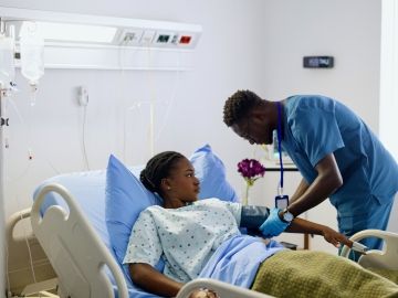 A nurse takes his patient's blood pressure.