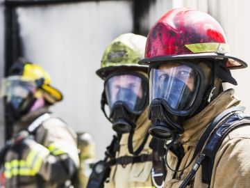 Three firefighters in their equipment are pictured.