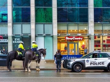 Toronto police officers in a car and on horses. 