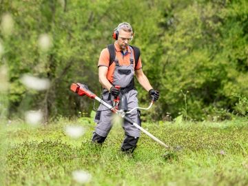 A landscape worker cutting grass.