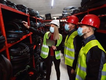 Workplace inspectors inspecting a workplace during COVID, as indicated by the masks they are wearing