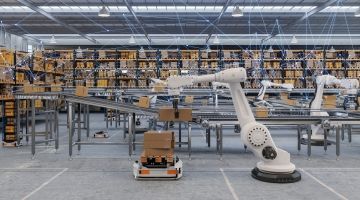 Robots lift boxes from a conveyor belt in a factory without human workers