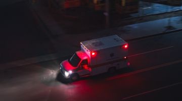 An overhead view of an ambulance driving at night.