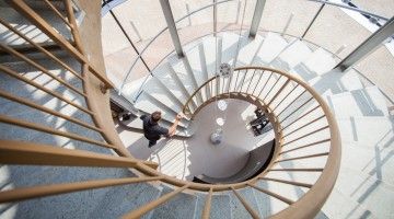 Top down view of man walking up spiral staircase