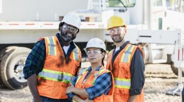 Three construction workers smile for the camera