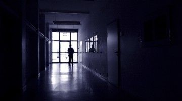 Silhouette of a worker in a darkened hallway