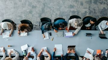 An overhead shot of a boardroom table full of people
