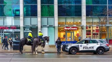 Toronto police officers in a car and on horses. 