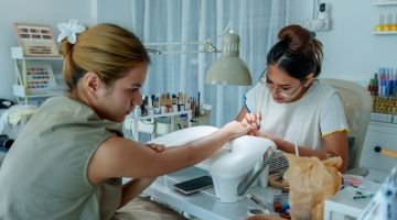 A nail technician works on a client's nails