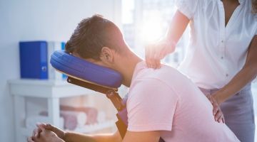 Physiotherapist treats man with back and neck pain Thumbnail