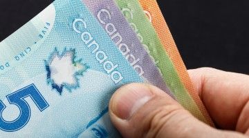 Close-up of fingers holding Canadian bills