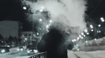 Person walking to work at night while smoking