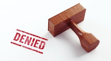 Close-up of a rubber stamp and the word "denied"
