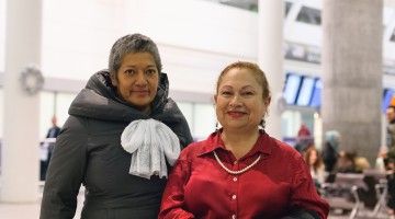 Two smiling women at the airport