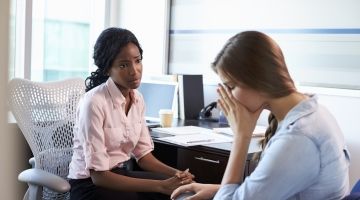 Woman consoling sad female co-worker