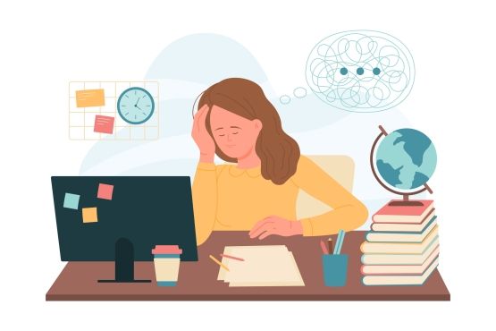 A woman at her laptop working late, head in her hand