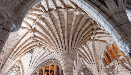 Stone arches and stain glass windows in the interior of the Canadian Parliament