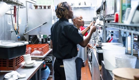 Two workers in a restaurant kitchen.
