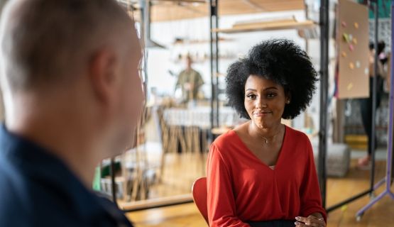 A woman smiles sympathetically at a colleague in an office