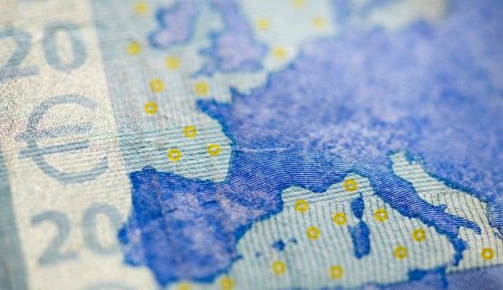 Close-up of Euro bill and map of Europe