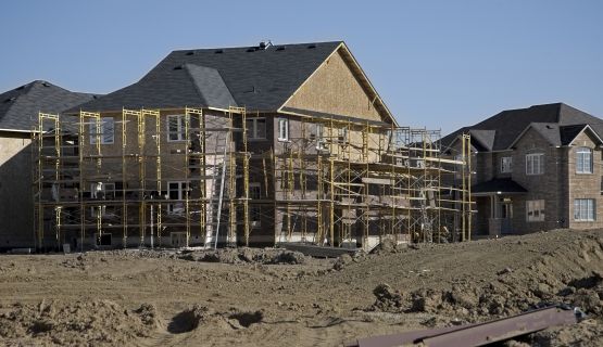 A residential home in mid-build is surrounded by scaffolding 