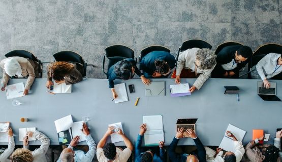 An overhead shot of a boardroom table full of people