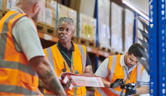 A warehouse manager delivers safety training to a worker