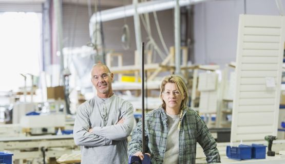 Two workers at a window shutters manufacturing shop floor