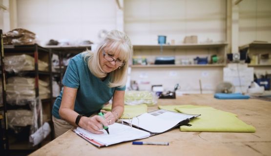 An older woman works in a workshop