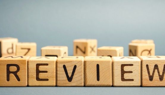 wooden letter tiles spell out the word "review"