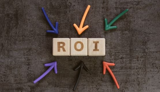 Wooden block letters spelling out R O I, with colourful arrows pointing to them
