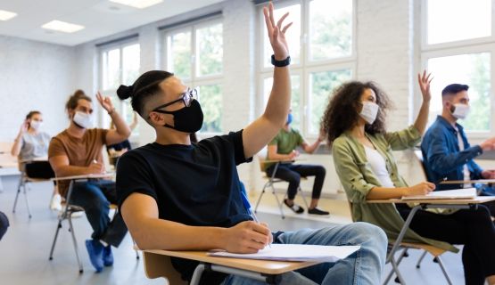 Masked university students in a classroom
