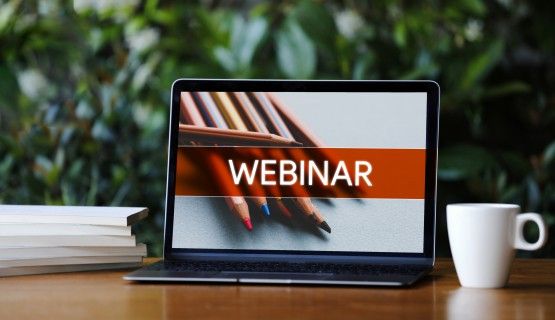 A laptop with the word "webinar" on the screen