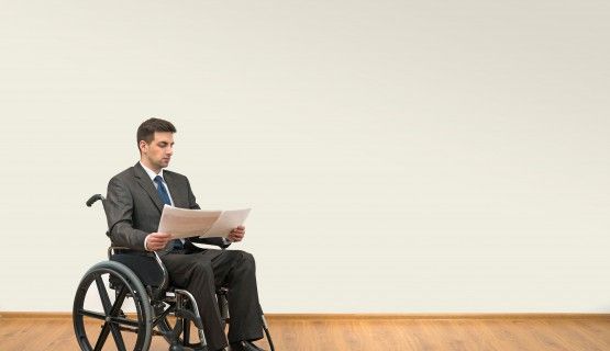 A man in a wheelchair reviewing documents