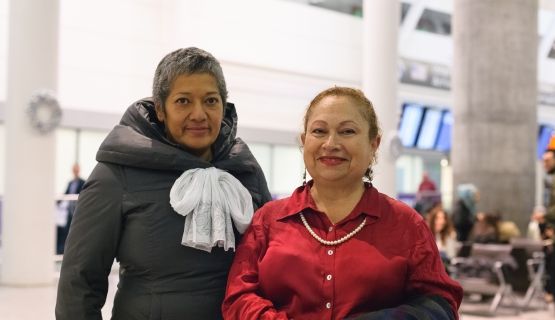 Two smiling women at the airport
