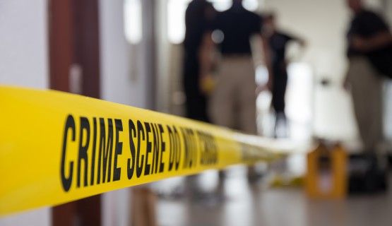 Investigators working behind crime-scene yellow tape