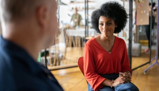 A woman smiles sympathetically at a colleague in an office