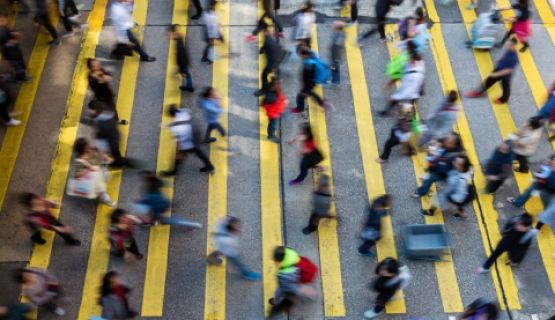 Overhead image of fast-moving pedestrians using a crosswalk to cross a road.