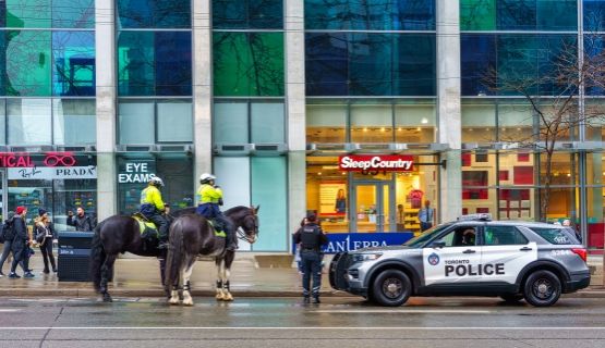 Toronto police officers in a car and on horses. 