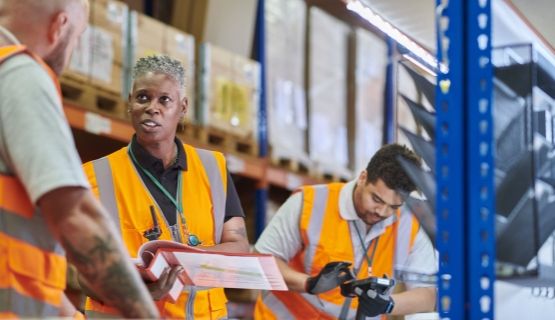A warehouse manager delivers safety training to a worker